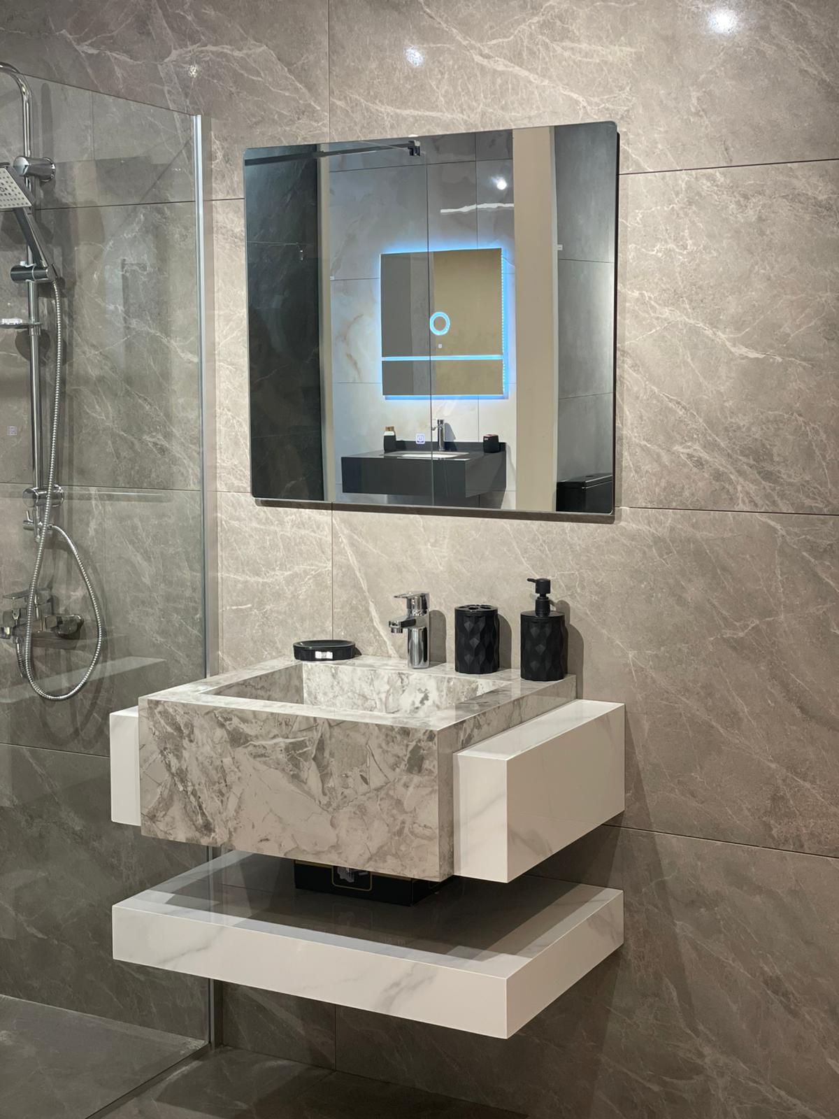 Moderna kupatilska oprema sa elegantnim lavabo elementom od mermera i minimalističkim ogledalom, koje dodaje sofisticiranost prostoru.