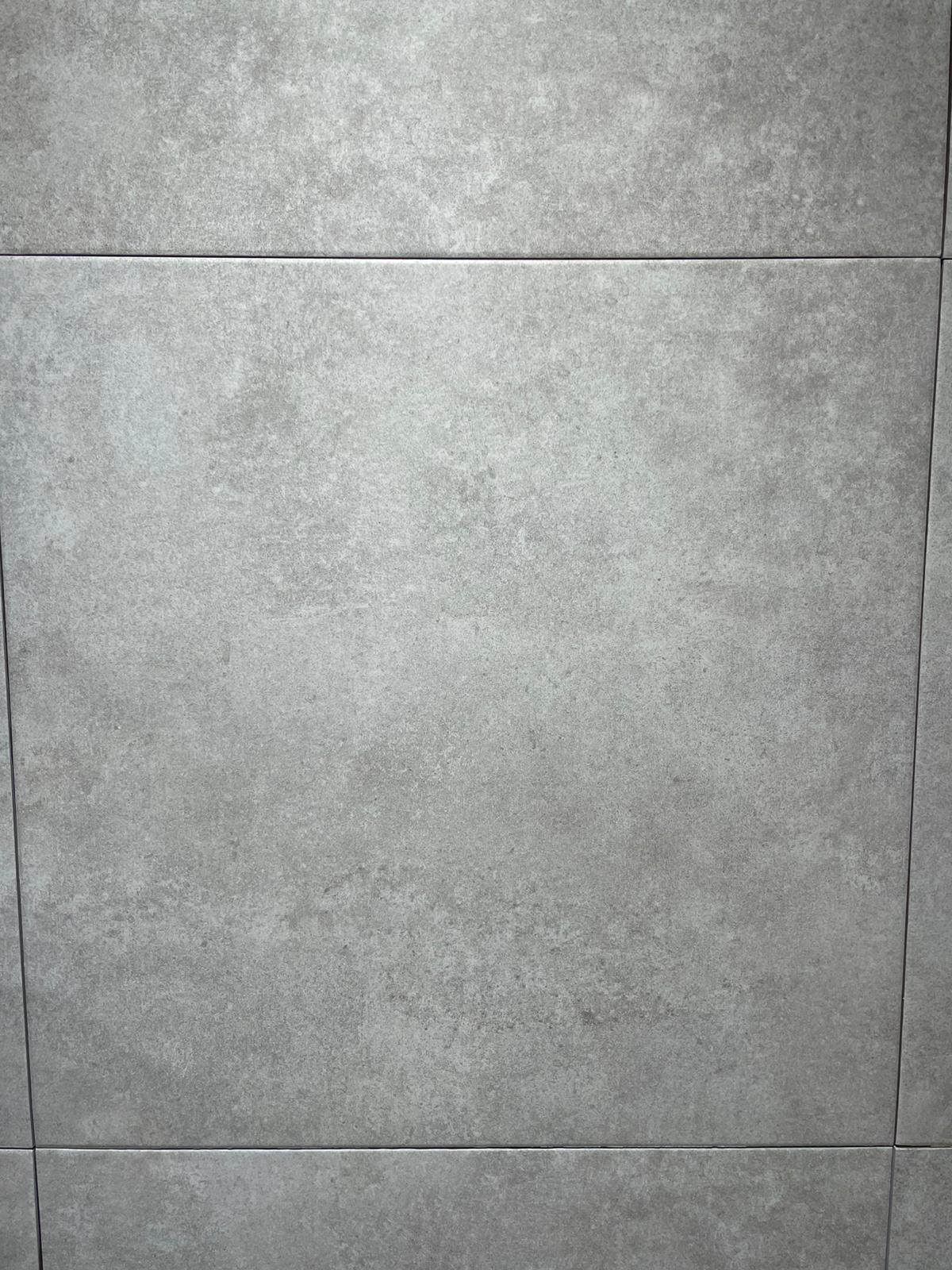 Ova slika prikazuje moderne keramičke pločice u svetlosivoj boji, koje su idealne za savremena kupatila. Njihova tekstura i boja doprinose minimalističkom i elegantnom izgledu prostora.