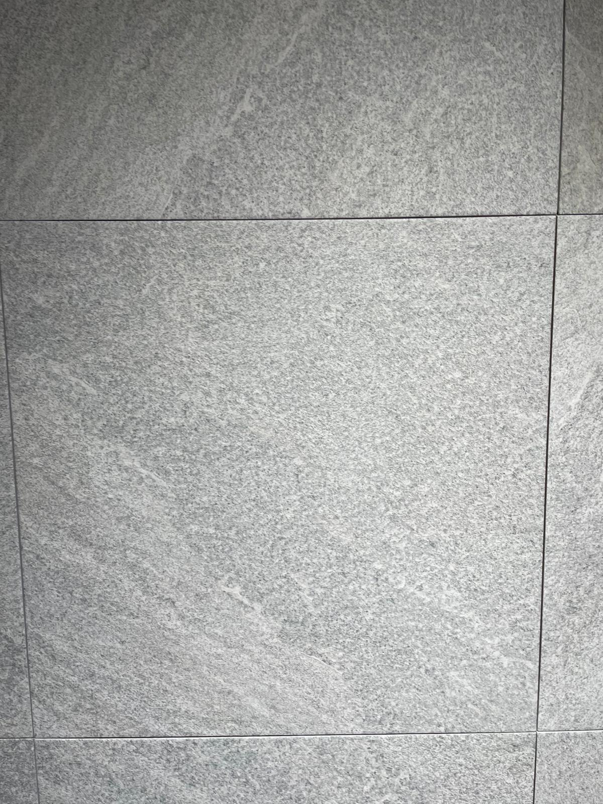 Ova slika prikazuje elegantne sivo-bež pločice koje se mogu koristiti za oblaganje zidova ili podova u kupatilu, pružajući moderan i sofisticiran izgled.